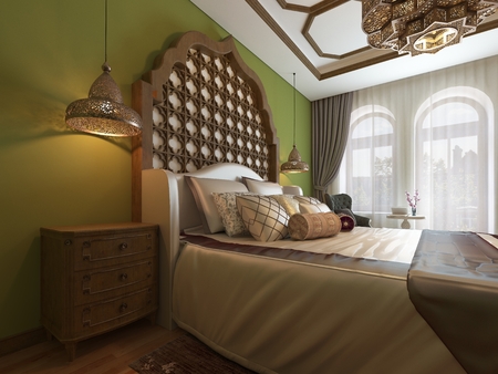 Oriental bedroom in Arab style, with a wooden headboard and green walls. TV unit, dressing table, armchair with coffee table. 3D rendering.の写真素材