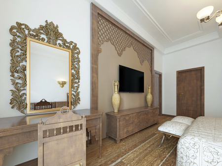A TV on the wall and a TV stand with a dressing table, wooden carvings framed in Middle Eastern Arabic style. 3D rendering.の写真素材