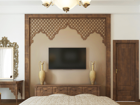 A TV set on the wall and a TV stand with wooden carvings of a Middle Eastern Arabic style. 3D rendering.の写真素材