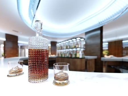 A decanter with alcohol and two glasses on a white marble countertop. 3d rendering.の写真素材
