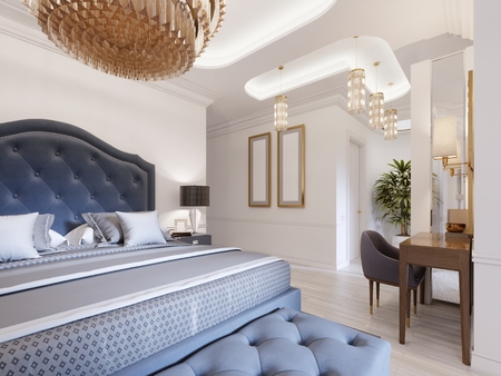 A luxurious bedroom in a classic style with gold elements and a blue bed cloth and a wooden dresser and dressing table. 3d rendering.の写真素材