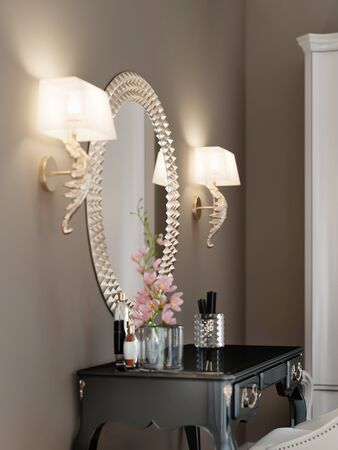 A round mirror with a golden rim on the wall, two sconces on each side, above the dressing table. 3D rendering.の写真素材