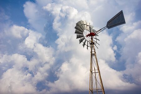 Old farm windmill against a cloudy skyの写真素材
