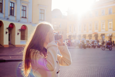 woman making photos of the city using vintage film cameraの写真素材