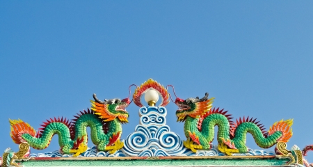 Twin dragon statues in Chinese style on top of general temple roof の写真素材
