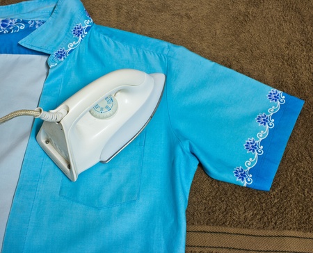  iron and a blue shirt on a brown towelの写真素材