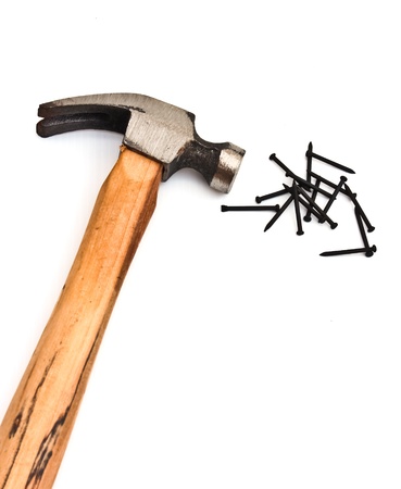hand hammer with pile of black nails over whiteの写真素材