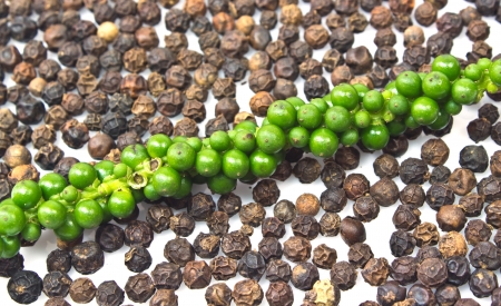 Fresh green peper on heap of Black Pepper,Thai Indian Spiceの写真素材