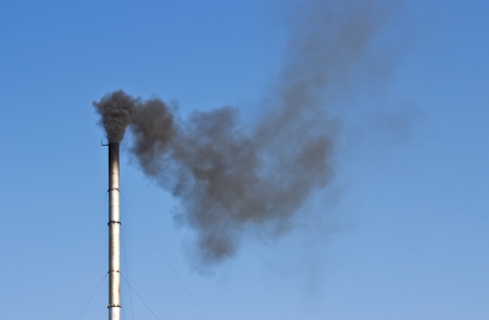 industrial smoke from chimney on blue skyの写真素材