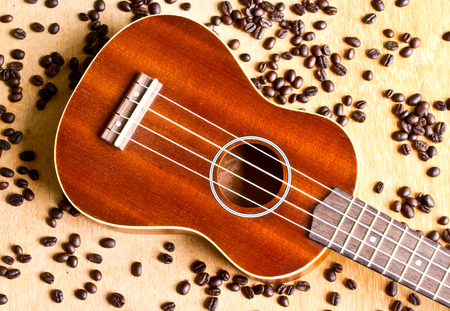 Coffee beans and Ukulele on wood の写真素材