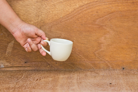 hand give your mug on a wooden floor.の写真素材