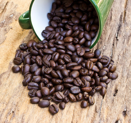 A Cup of coffee beans is on wooden boardの写真素材