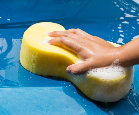 hand hold sponge over the car for washingの写真素材