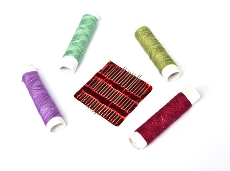 many color thread and needle  on white