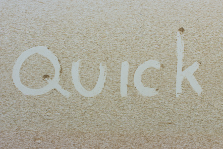 "Quick" written on a dirty carの写真素材