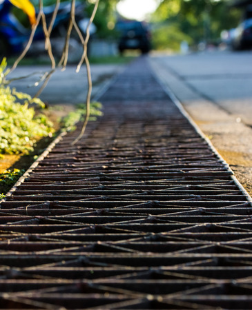 Old steel drainage of the asphalt road.の写真素材