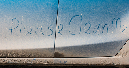 "Clean me" written on a dirty carの写真素材
