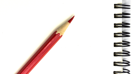 red pencil and notebook  on a white backgroundの写真素材