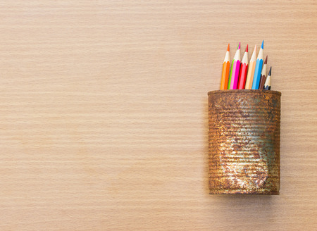 color pencils in rusty tin can, wood tableの写真素材