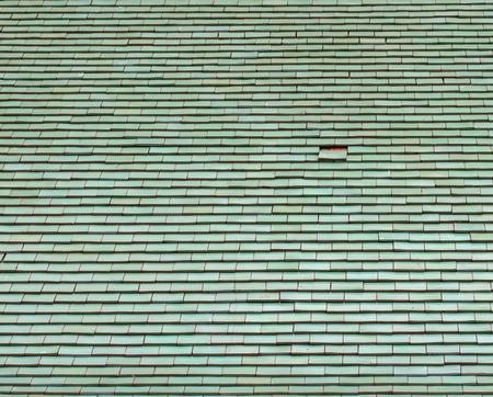 Green tiles roof and one tile missing.backgroundの写真素材