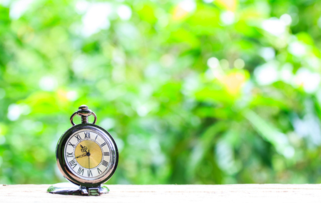 watch pocket placed on wooden floor with boke background.