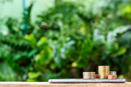 smart phone with stack of coins on top. business finance conceptの写真素材