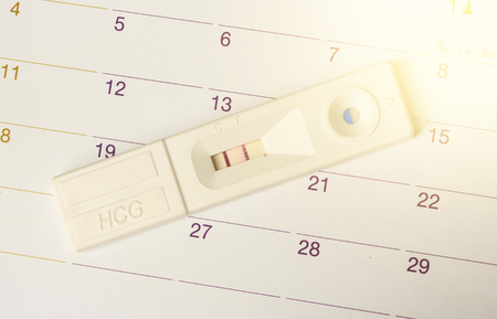 Pregnancy test on calendar background. Pregnancy care conceptの写真素材