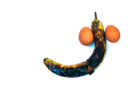 Eggplant and eggs are placed on a white background. Looks like a penis symbol.の写真素材