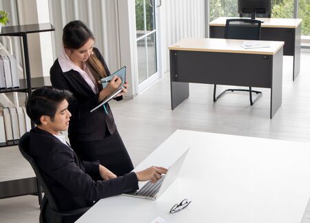 Company executive coaching young personal secretary assistant, team leader or senior manager explaining work duties to junior, businessman telling contractual terms or deal details to female partnerの写真素材