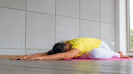 Beautiful asian young woman wearing sportswear practicing yoga in studio, natural light.Concept :...