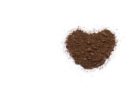 The soil on a white background with a heart shape conveys love and care.の写真素材