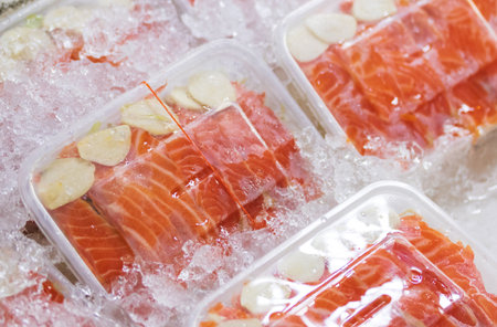 salmon sashimi (raw) sliced stacked in a plastic food containerの写真素材