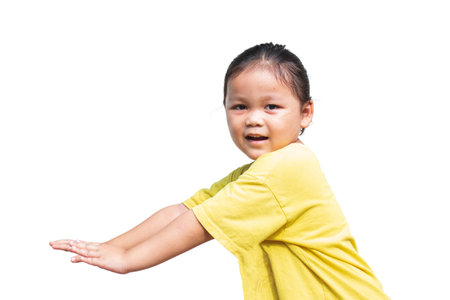 Cute Asian child wearing yellow shirt posing on white backgroundの写真素材