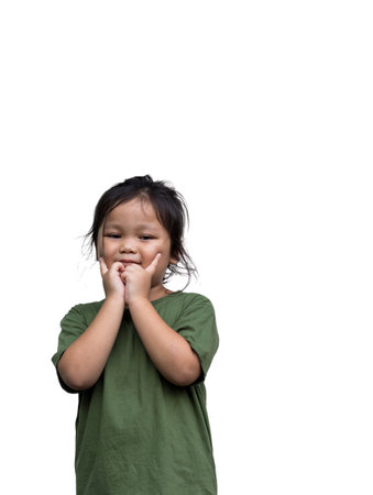 Young smiling asian girl wearing green dress holding hands up with two fingersの写真素材
