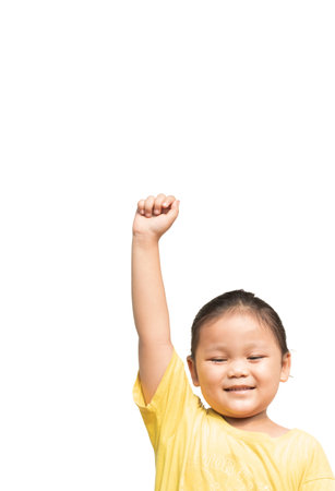 Cute Asian child wearing yellow shirt raising hands on white backgroundの写真素材