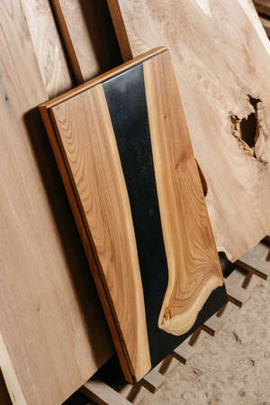 Exclusive handmade table of solid wood and epoxy resin on the background of wood boards