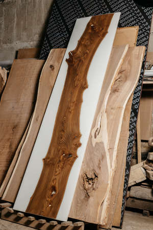 Exclusive handmade table of solid wood and epoxy resin on the background of wood boardsの写真素材
