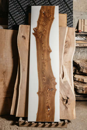 Exclusive handmade table of solid wood and epoxy resin on the background of wood boardsの写真素材