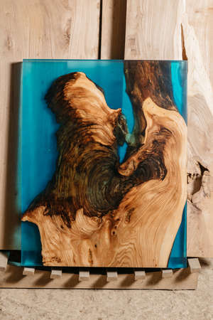 Exclusive handmade table of solid wood and epoxy resin on the background of wood boardsの写真素材