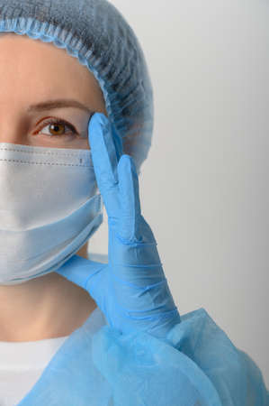 Doctor or nurse in a medical gown, mask and protective glovesの写真素材