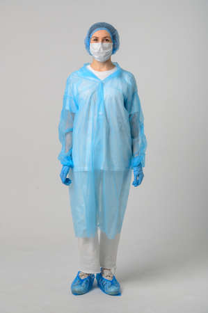 Doctor or nurse in a medical gown, mask and protective glovesの写真素材