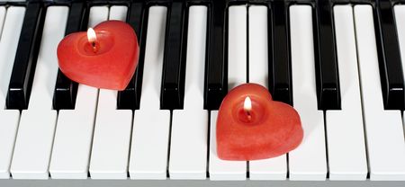 Piano keys with two heart-shaped candlesの写真素材