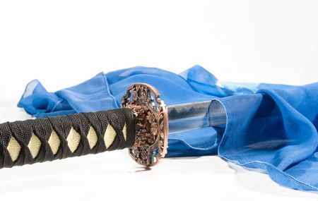 Close-up of a Japanese sword and a blue silk scarf (on white)の写真素材