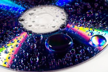 Closeup of drops of water (with beautiful reflections) on a multicolored surfaceの写真素材