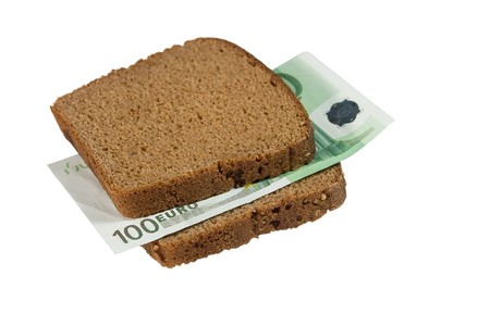 One-hundred euro bill between two slices of brown bread (isolated on white)の写真素材