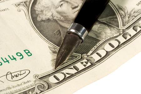 Closeup of a pen on dollar bills (isolated on white)の写真素材