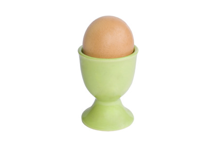 Brown egg in an egg cup isolated on whiteの写真素材