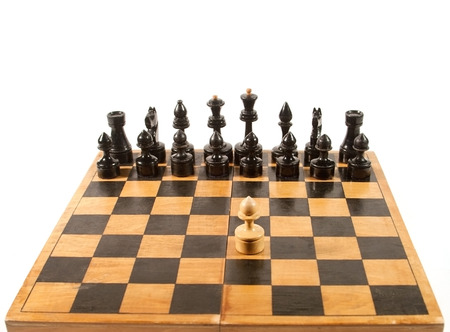 Rows of black chess figures and a single white pawn on the chessboard (isolated on white, with copy...