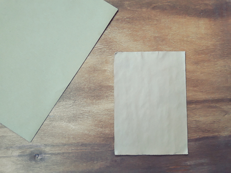 Blank old sheet of paper and an envelope on a worn wooden background (view from the top), retro styleの写真素材