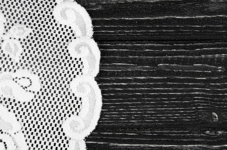 White lace napkin on a black wooden background with copyspace on the right (as a vintage background)の写真素材
